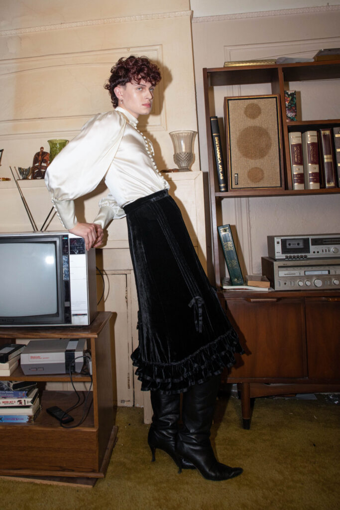 White shirt and black skirt with heeled boots.